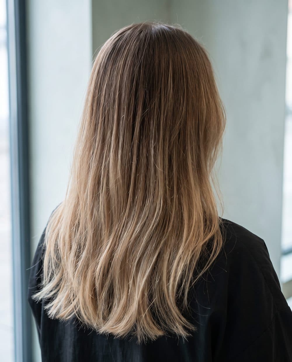 Hand painted balayage seen from behind: a soft root shadow melting into lighter mid lengths and ends, no line where it starts