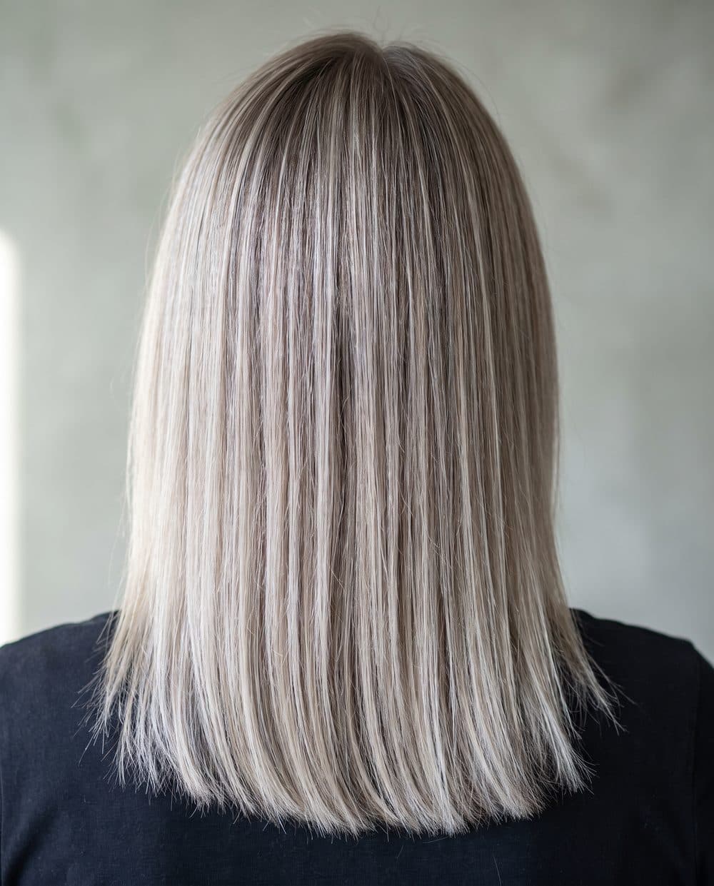 A cool blonde full head of foils seen from behind, many close tones rather than one flat colour, clean at the root