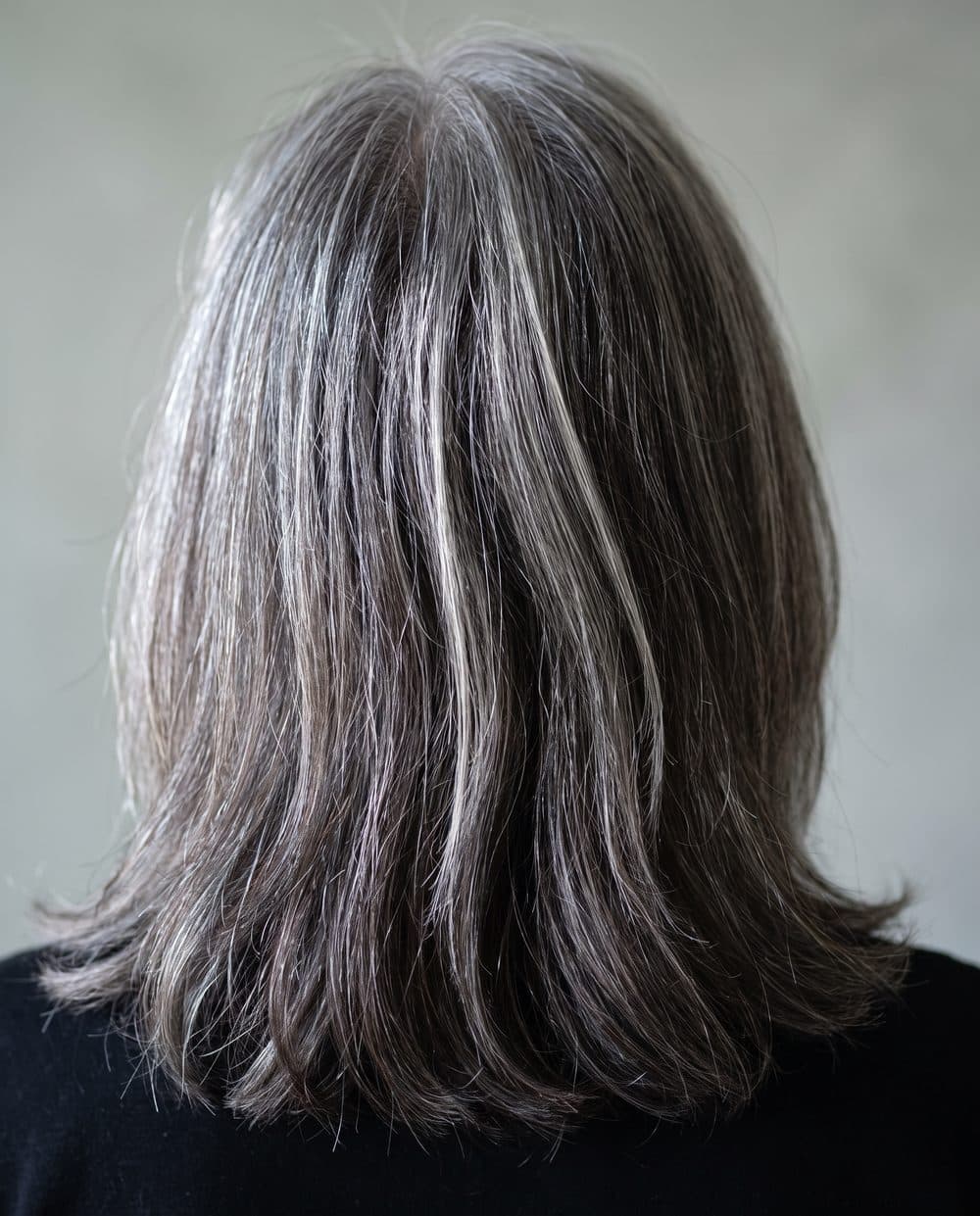Silver greys woven and softened through a darker base rather than covered over, seen from behind at the window