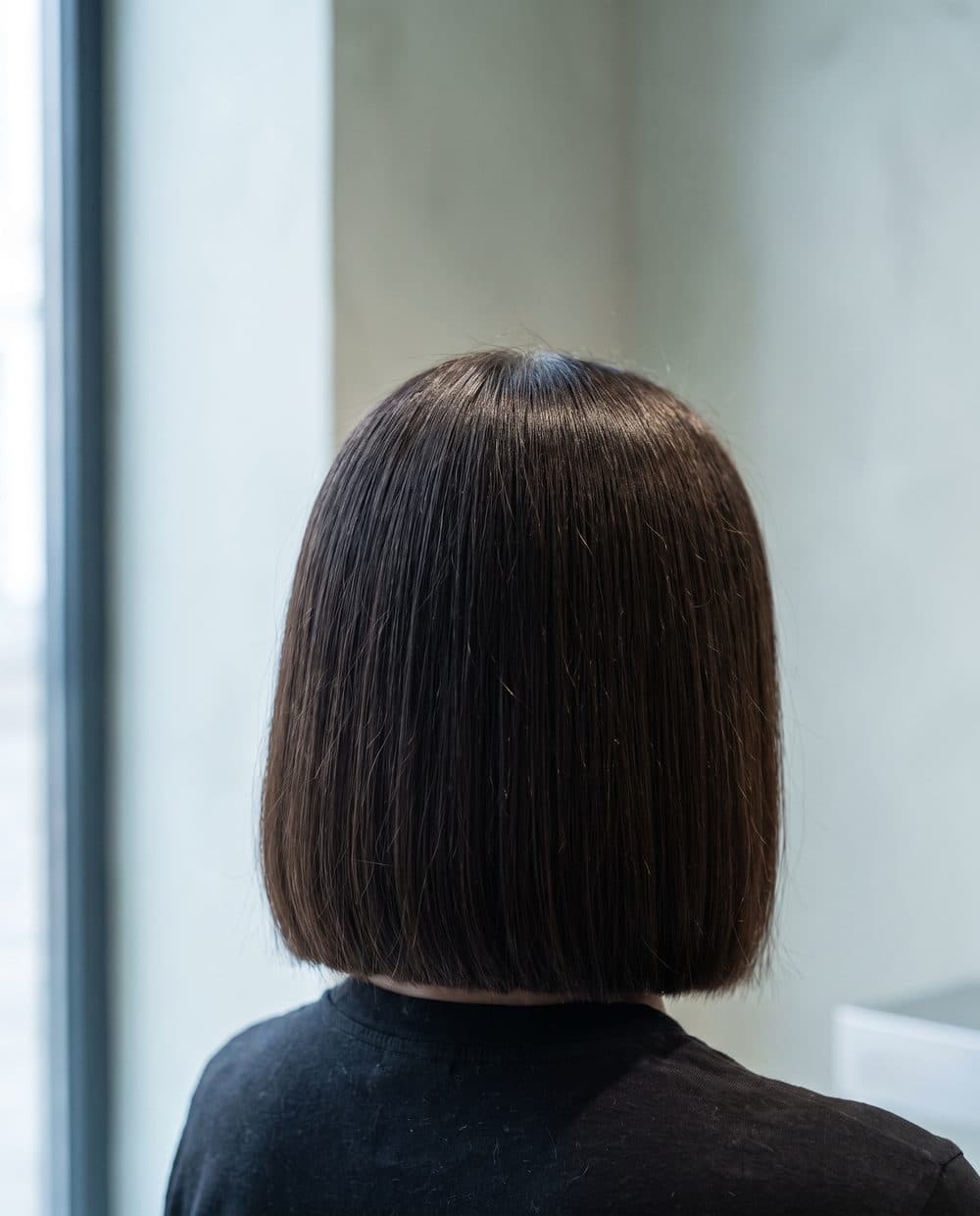 A blunt precision bob seen square on from behind, one clean unbroken line sitting level at the jaw